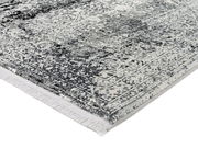 Nahaufnahme eines Designer-Teppichs mit grauem und weißem Muster, perspektivisch von der Seite aufgenommen.