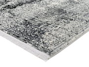 Nahaufnahme eines Designer-Teppichs mit grauem und weißem Muster, perspektivisch von der Seite aufgenommen.