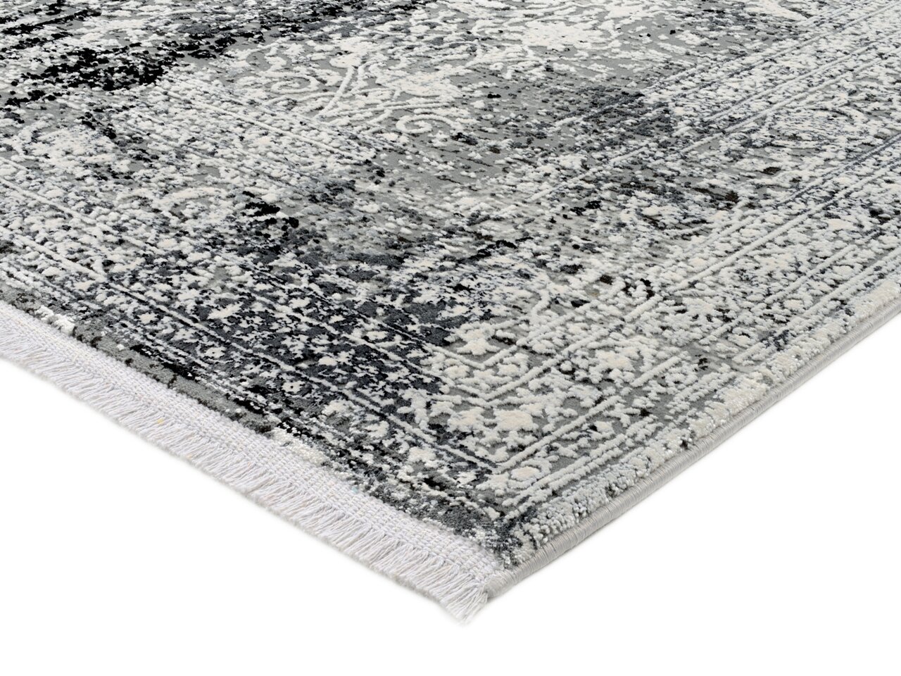 Nahaufnahme eines Designer-Teppichs mit grauem und weißem Muster, perspektivisch von der Seite aufgenommen.