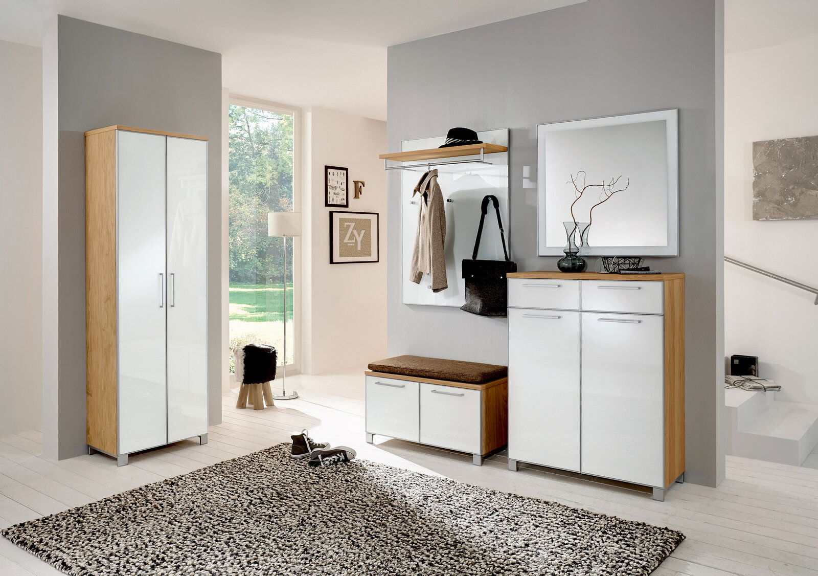 Moderne Garderobeneinrichtung mit Dielenschrank, Schuhschrank, Garderobenpaneel und Spiegel in heller, einladender Atmosphäre. Frontalansicht.