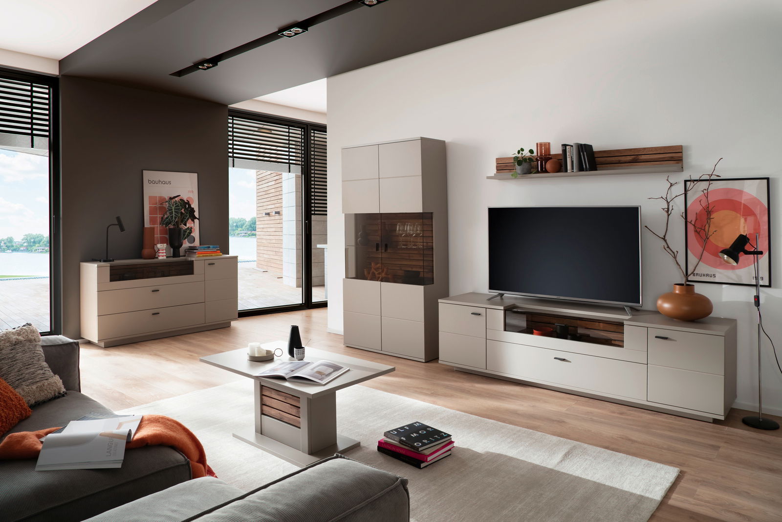 Modernes Wohnzimmer mit Sideboard LÜTTICH in heller Holzoptik, frontal betrachtet, neben einem großen Fenster mit Blick auf die Terrasse.