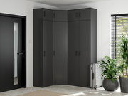 Eckschrank in modernem Design, dunkelgrau, in einer Ecke eines hellen Raumes mit Pflanzen und einem Koffer, seitliche Perspektive