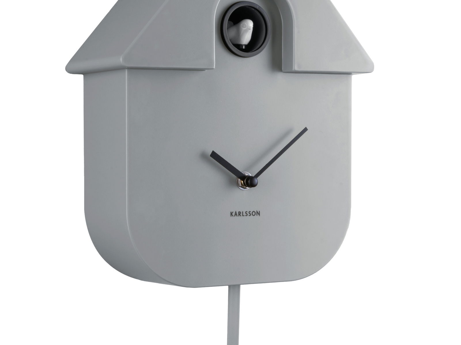 Graue Wanduhr in Form eines Vogelhauses mit schwarzem Zifferblatt und einem kleinen Vogel oben, seitliche Perspektive.