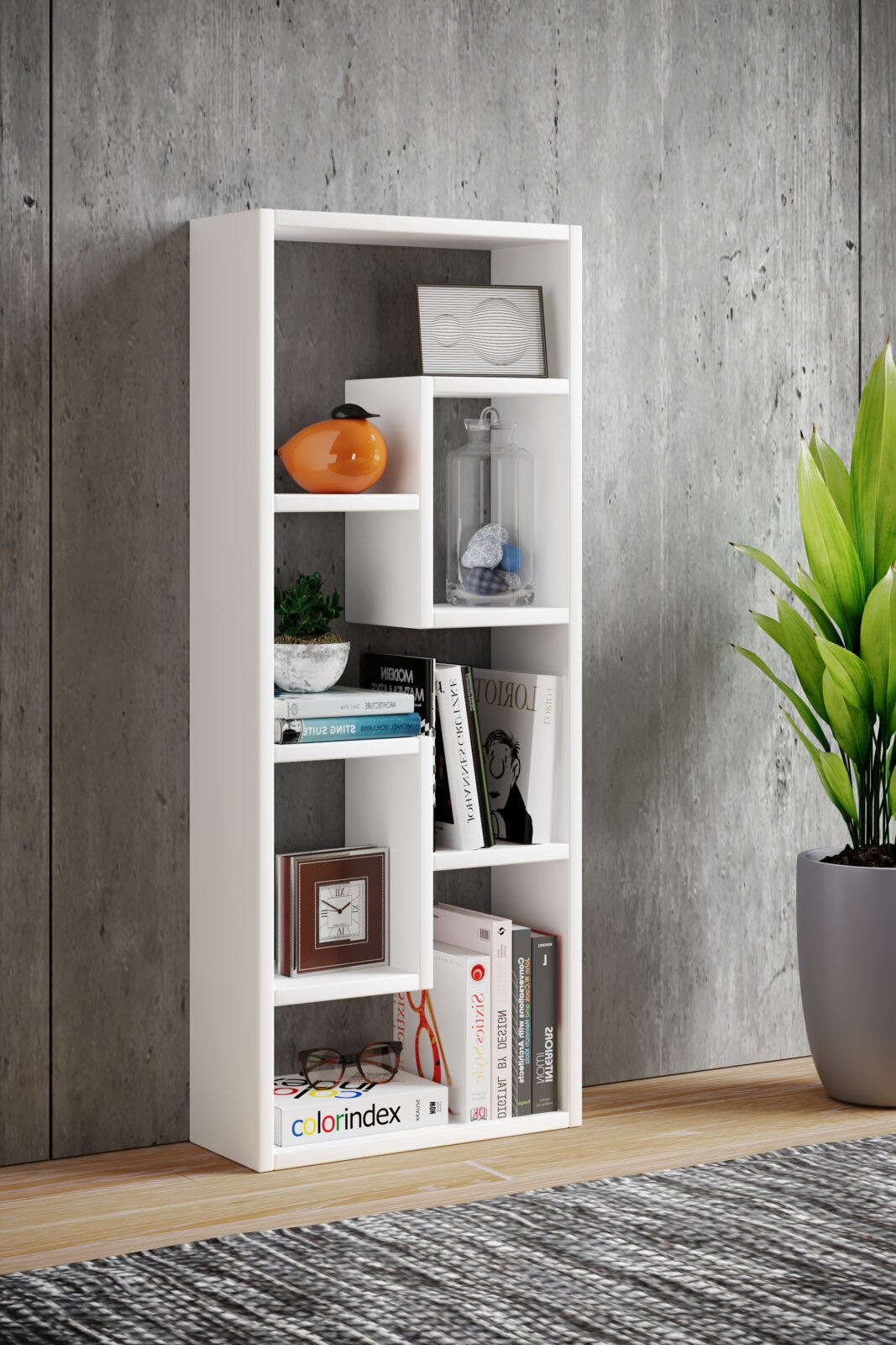 Modernes weißes Standregal mit versetzten Fächern, dekoriert mit Büchern und Deko-Objekten, im Wohnraum vor Betonwand – Perspektive: frontale Ansicht mit leichtem Winkel von links.