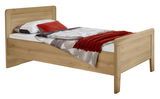 Holzbett in natürlicher Holzoptik mit Kopf- und Fußteil, seitliche Perspektive, dekoriert mit Bettwäsche und rotem Kissen.