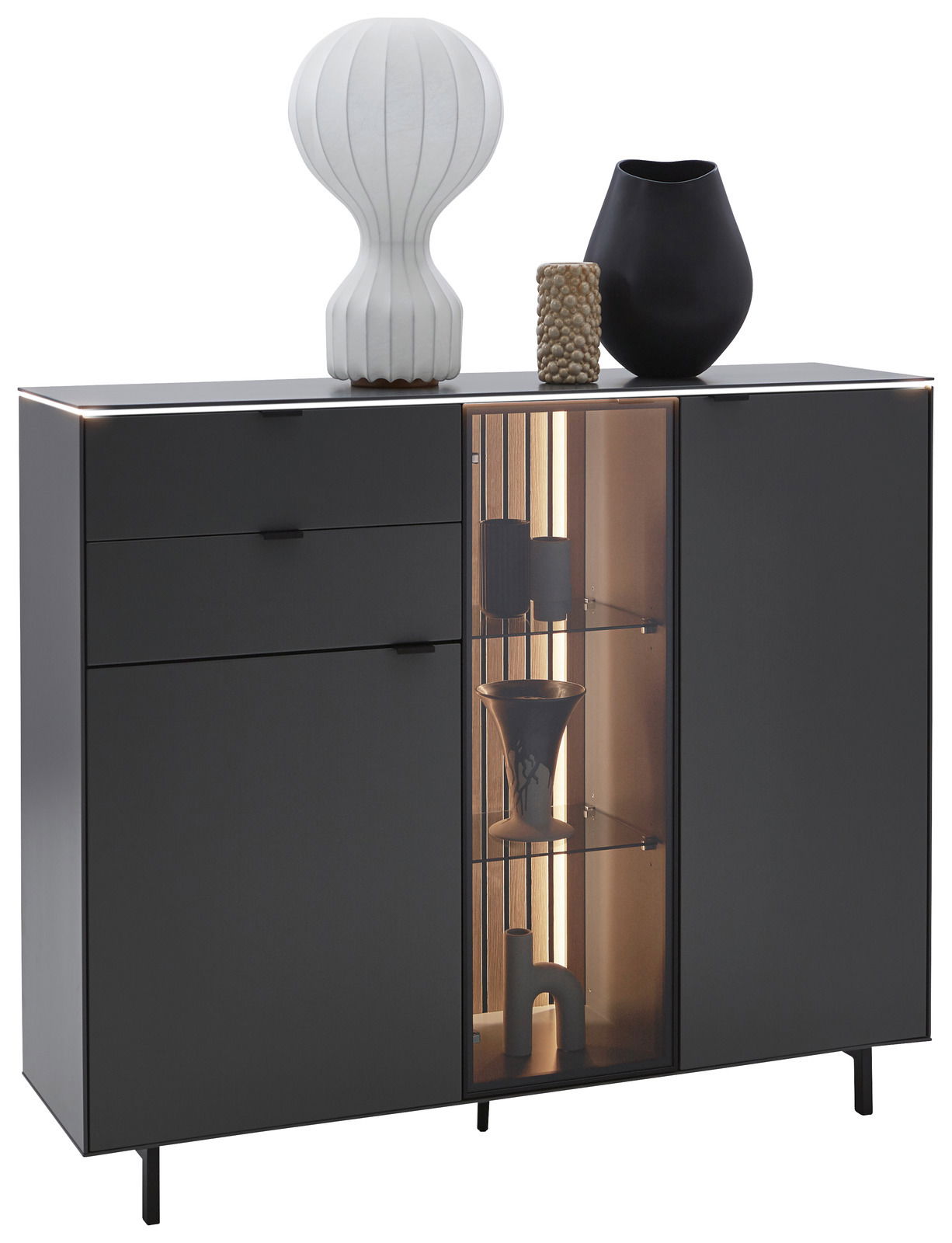 Frontansicht des Dieter Knoll Highboards RIANI in dunklem Design mit zwei Schubladen, einer Glastür mit Beleuchtung und dekorativen Vasen auf der Oberseite.