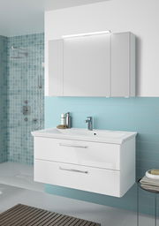 Moderner Badblock mit weißem Waschbecken und zwei Schubladen, frontal betrachtet, vor einer hellblauen gefliesten Wand.