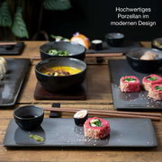 Sushi-Set aus hochwertigem Porzellan in modernem Design, präsentiert auf einem Holztisch aus der Vogelperspektive.