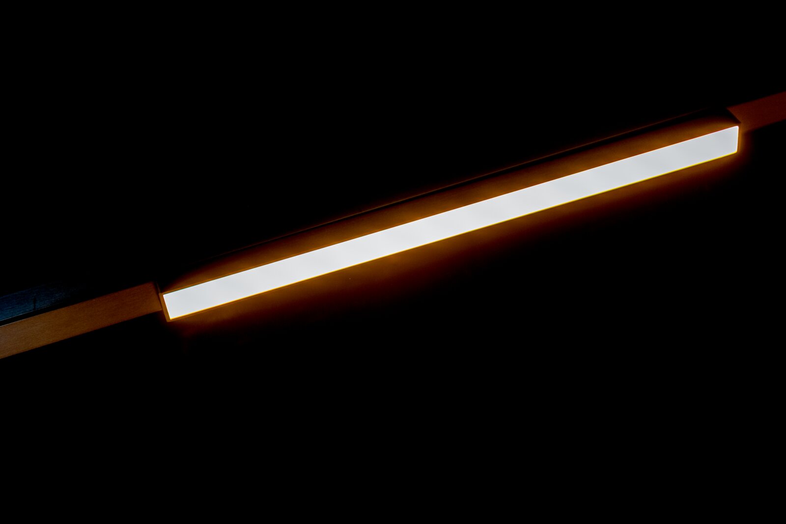 Schlanke LED-Lichtleiste mit warmweißem Licht an der Decke, perspektivische diagonale Ansicht von unten