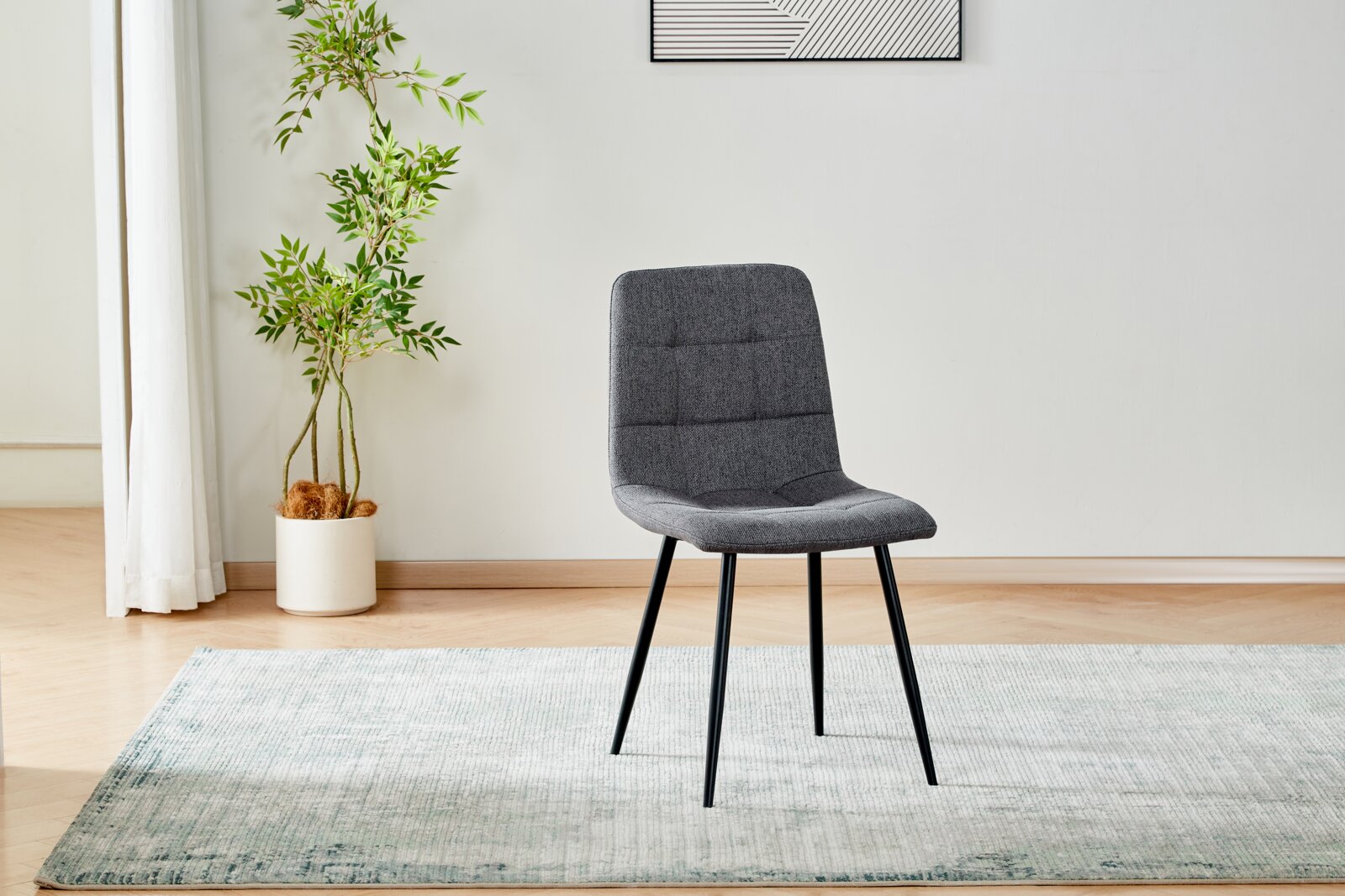 Moderner Polsterstuhl in Dunkelgrau mit schwarzem Metallgestell auf hellem Teppich in minimalistischer Wohnumgebung, Ansicht schräg von vorne