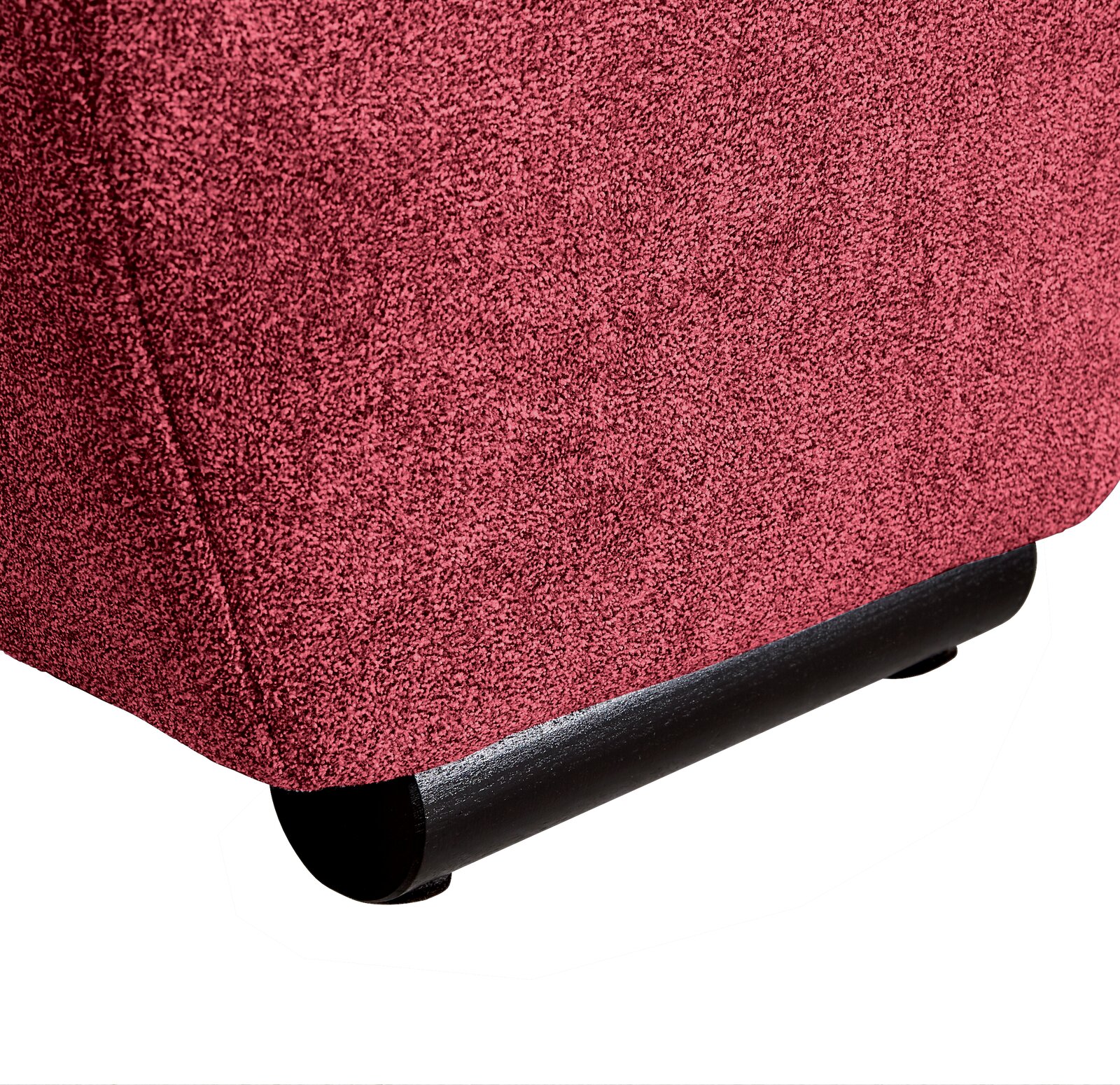 Nahaufnahme der unteren Ecke eines Big-Sofas in rotem Stoff mit schwarzem Fuß, seitliche Perspektive.
