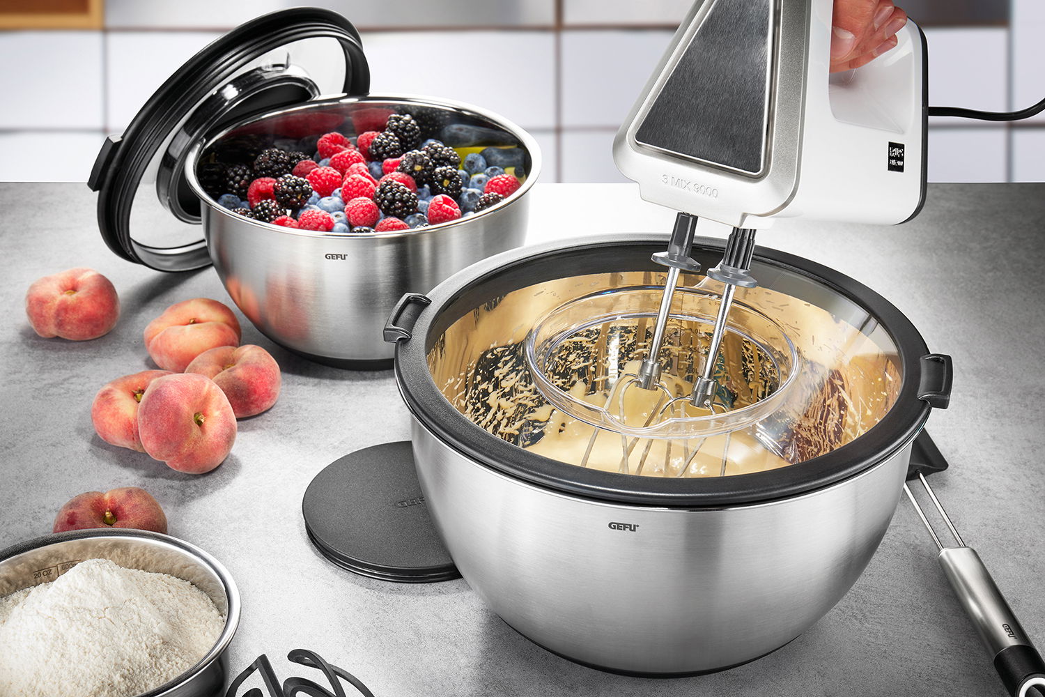 Schüssel-Set mit Spritzschutzdeckel, gefüllt mit Beeren und Teig, aus der Perspektive von oben betrachtet.