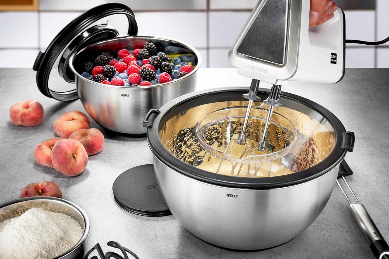 GEFU Schüssel-Set mit Spritzschutzd MUOVO Schüssel-Set mit Spritzschutzdeckel, gefüllt mit Beeren und Teig, aus der Perspektive von oben betrachtet.