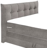 Graues Boxspringbett mit gepolstertem Kopfteil, seitliche Perspektive