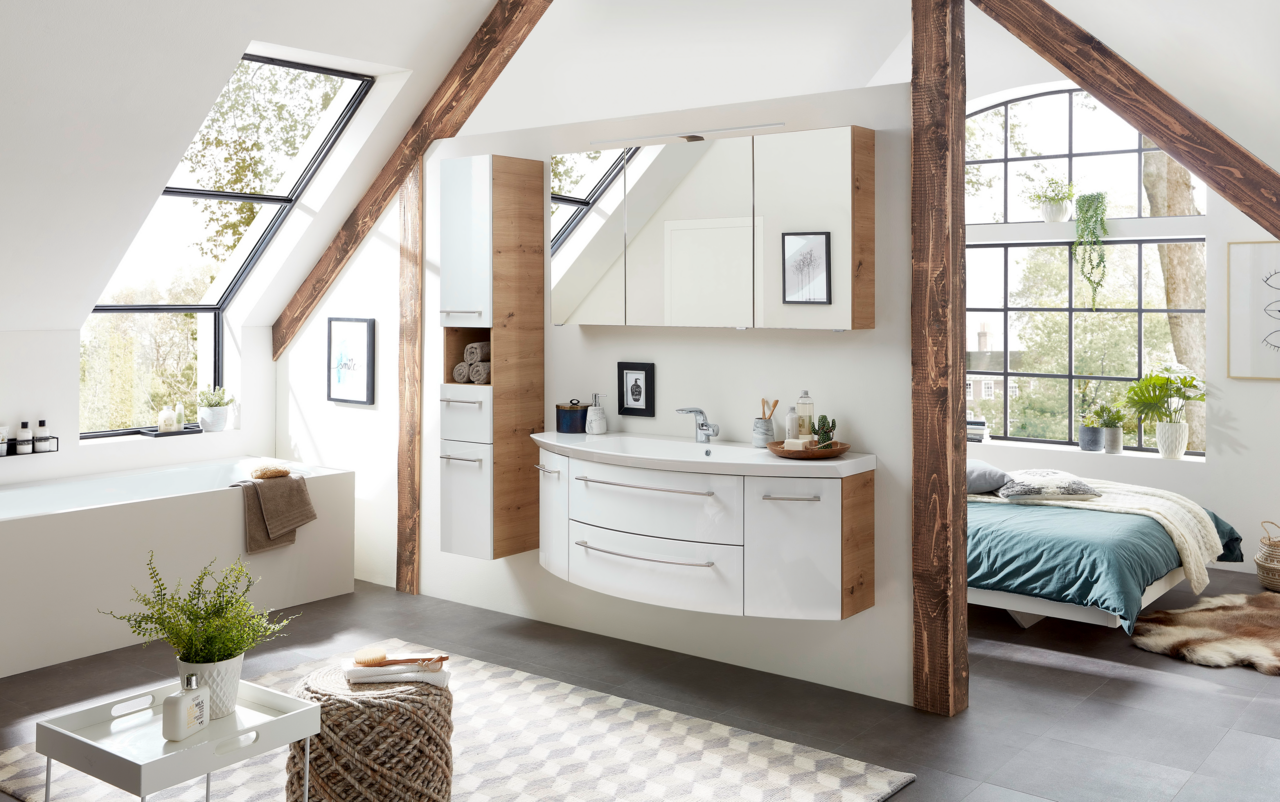 Moderne Badkombination in einem hellen Dachgeschossbad mit Holz- und Weißtönen, bestehend aus einem Waschtisch mit Schubladen und einem Spiegelschrank, seitliche Perspektive.