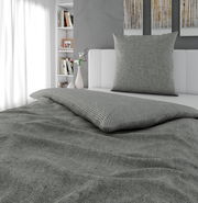 Graue Wendebettwäsche in einem modernen Schlafzimmer, seitliche Perspektive