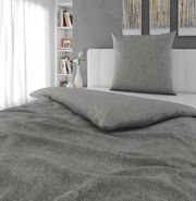 Graue Wendebettwäsche in einem modernen Schlafzimmer, seitliche Perspektive