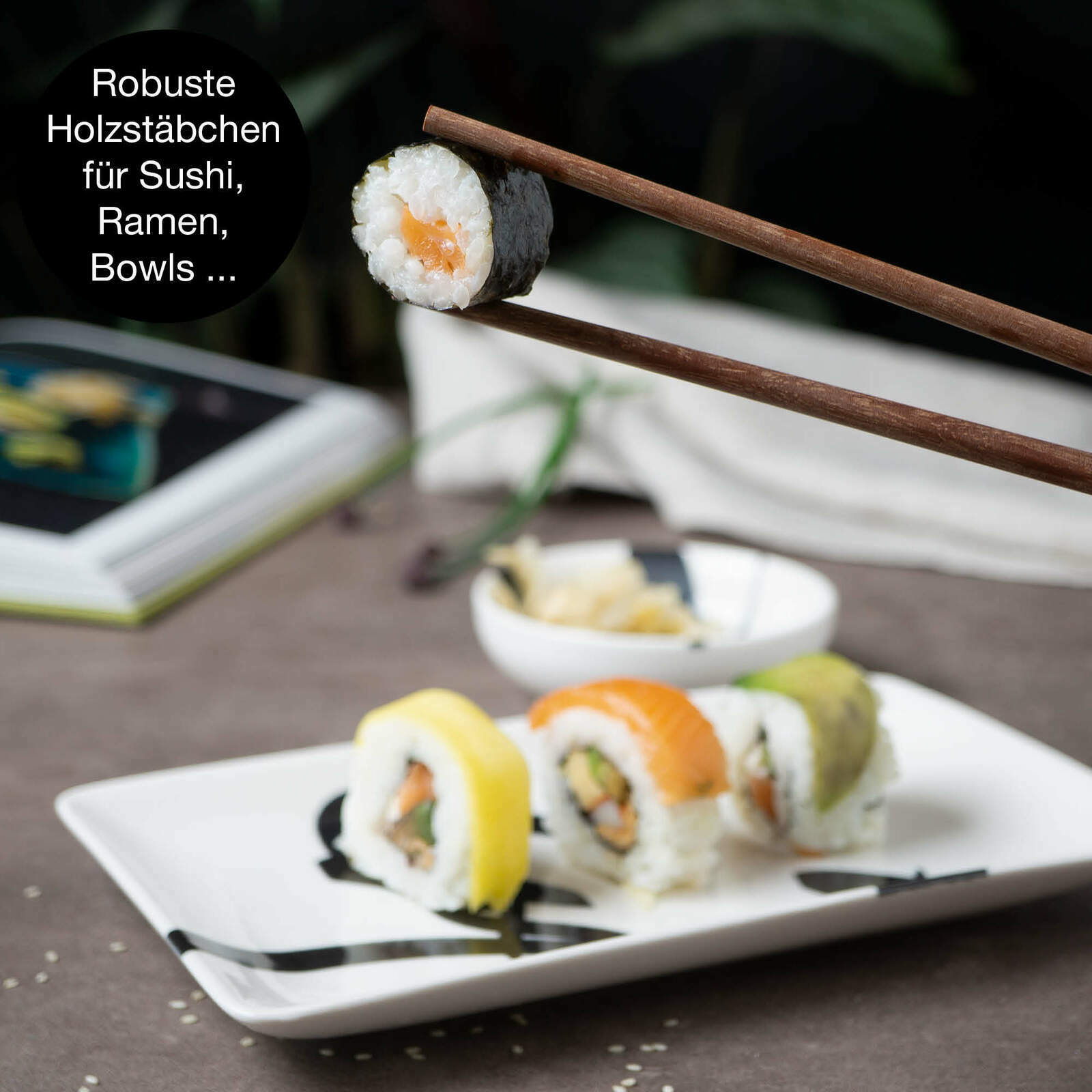 Nahaufnahme eines Sushi-Sets mit robusten Holzstäbchen, die ein Sushi-Röllchen halten. Im Hintergrund sind weitere Sushi-Rollen auf einem Teller zu sehen.