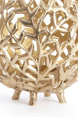 Nahaufnahme eines goldenen Teelichthalters mit filigranem, blattähnlichem Muster und kleinen Füßen, seitliche Perspektive.