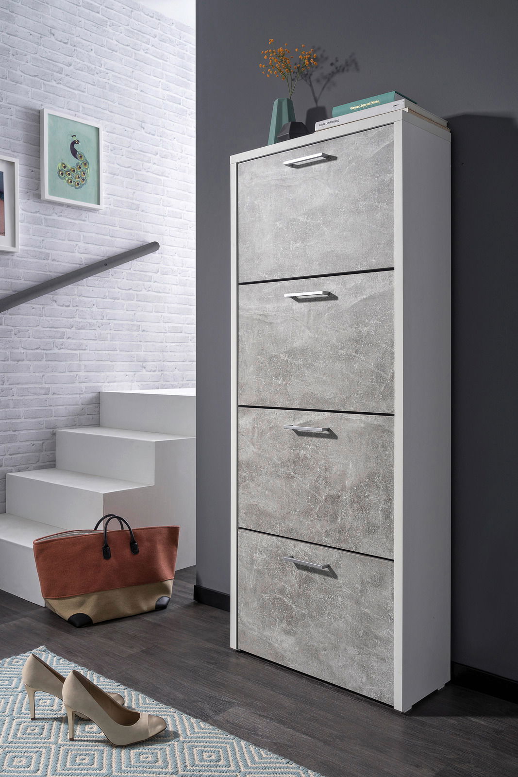Moderner Schuhkipper mit vier Klappen in Betonoptik, seitliche Perspektive, platziert in einem stilvollen Flur mit Dekoration.