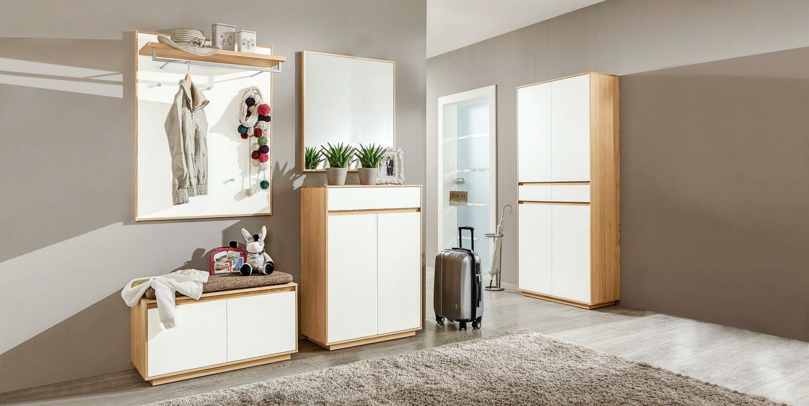 Moderne Garderobeneinrichtung mit Holz- und Weißelementen, bestehend aus Garderobenbank, Schuhschrank, Spiegel und Garderobenpaneel, seitliche Perspektive.
