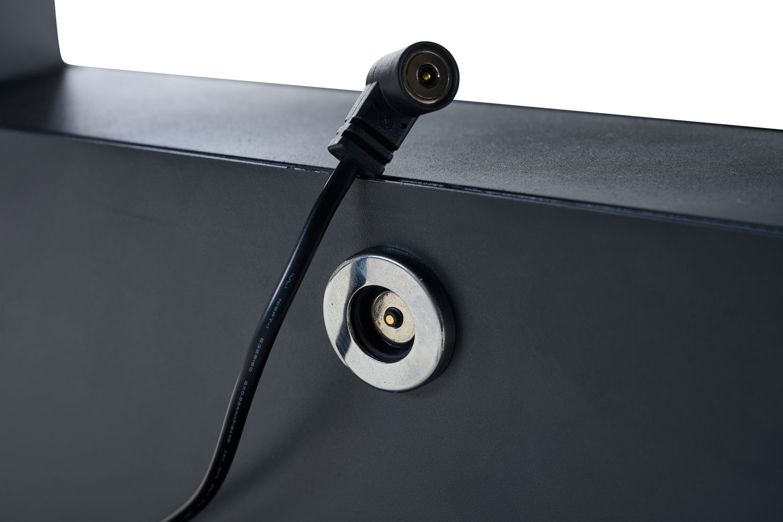 Nahaufnahme eines elektrischen Anschlusses an einem Garten E-Lifttisch, seitliche Perspektive.