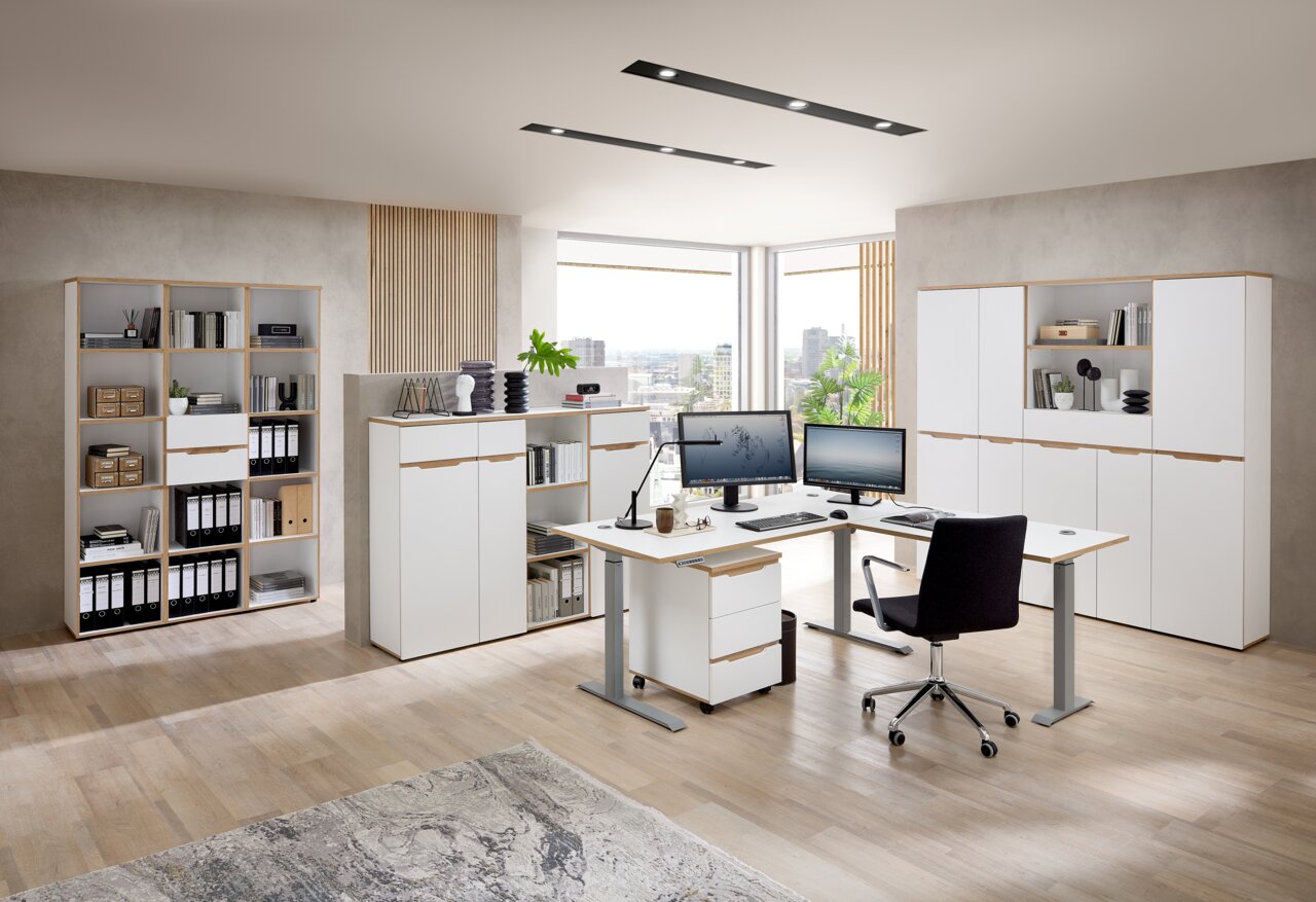 Voleo E-Eckschreibtisch DETROIT Moderne Büromöbel in einem hellen Raum mit Schreibtischen, Aktenschränken und Regalen, aus der Perspektive eines Betrachters im Raum.
