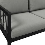 Nahaufnahme einer modernen Gartenbank mit grauen Kissen und schwarzem Metallrahmen, seitliche Perspektive.