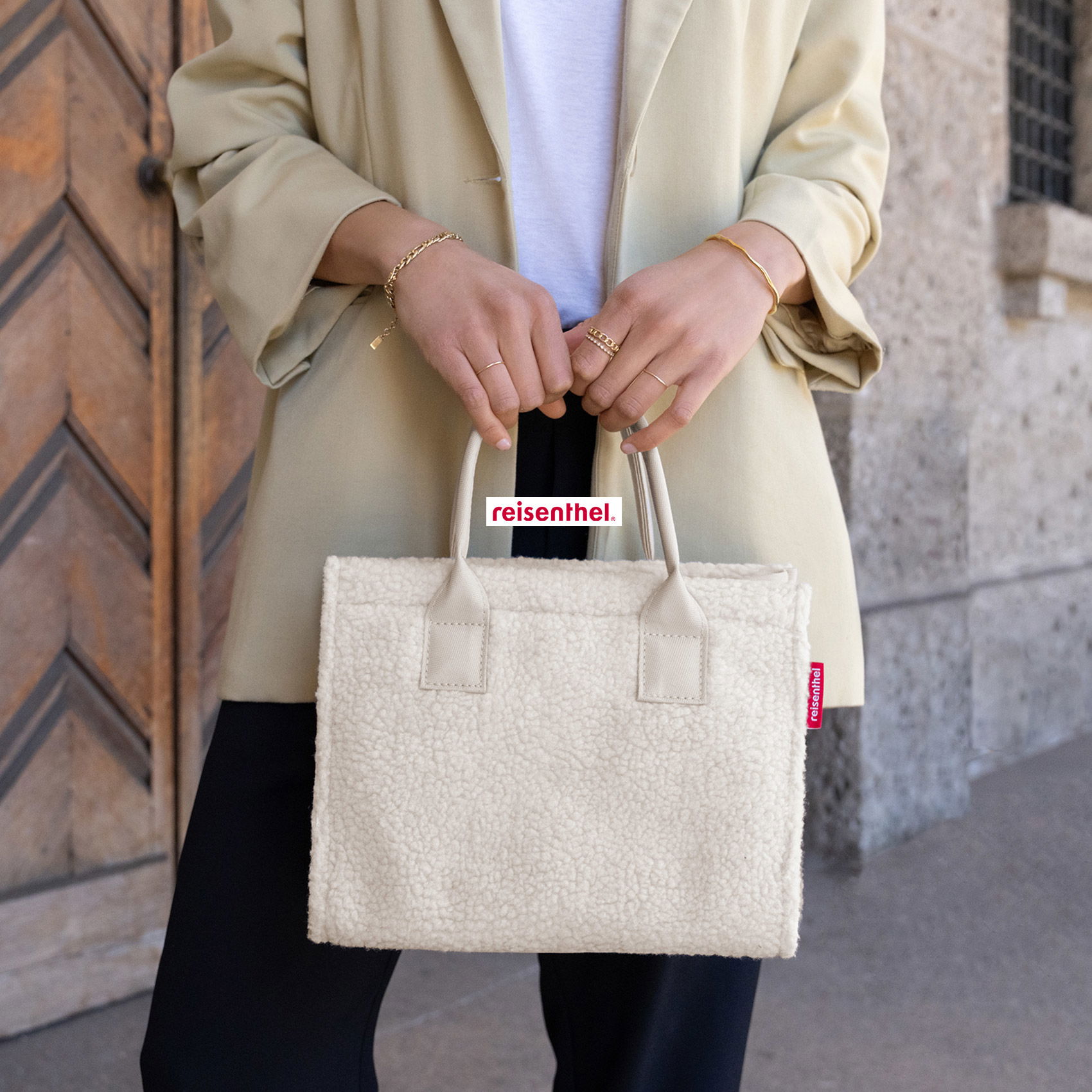 Stylische Reisenthel-Teddyfell-Tasche in Creme, elegant präsentiert im modernen City-Look.
