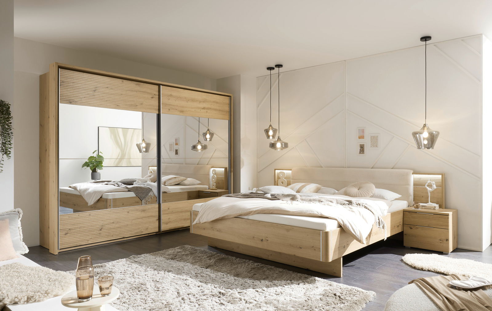 Modernes Schlafzimmer mit einem großen Kleiderschrank mit Spiegeltüren und einem gemütlichen Doppelbett aus Holz, seitliche Perspektive.