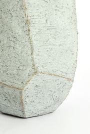 Nahaufnahme eines strukturierten, geometrischen Topfes aus Beton mit rauer Oberfläche.