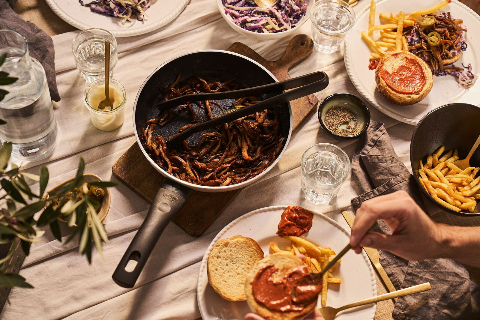Bratpfanne mit gebratenem Gemüse auf einem gedeckten Tisch, von oben fotografiert.