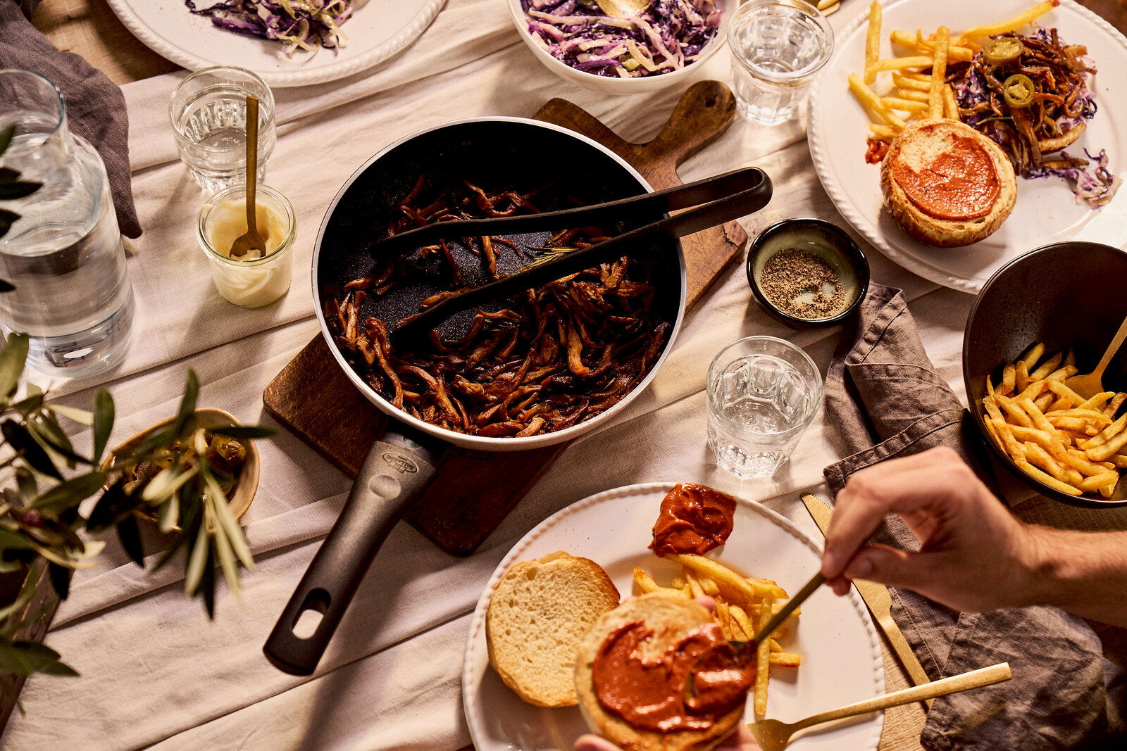 Bratpfanne mit gebratenem Gemüse auf einem gedeckten Tisch, von oben fotografiert.