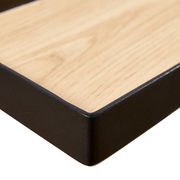 Nahaufnahme eines XORA Wandboards RICKY mit Holzoptik und schwarzem Rahmen, perspektivisch von der Ecke aufgenommen.