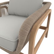 Nahaufnahme eines Lounge-Sessels mit hellgrauem Kissen und einem Rahmen aus hellem Holz, seitliche Perspektive.