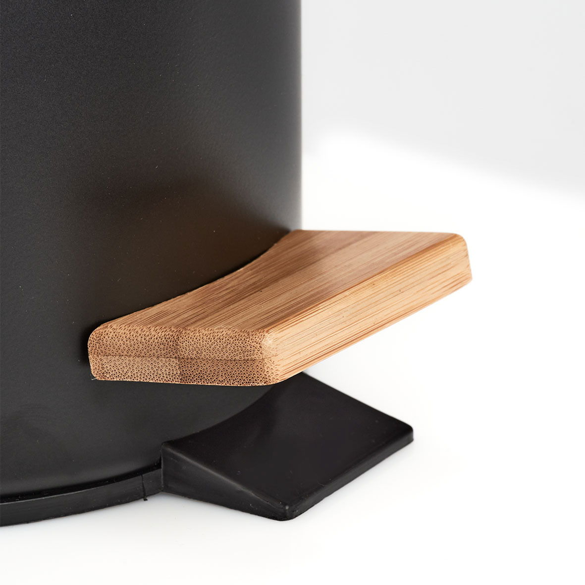 Nahaufnahme eines schwarzen Kosmetikeimers mit einem Bambus-Pedaldeckel, seitliche Perspektive