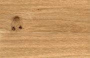 Nahaufnahme einer Holzoberfläche mit natürlicher Maserung und Astloch.