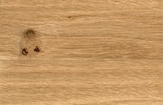Close-up van een houten oppervlak met natuurlijke nerf en knoesten.