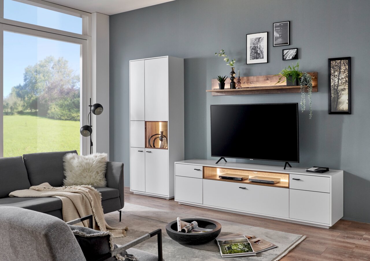 Moderne woonkamerwandcombinatie in wit met tv-kast, vitrinekast en wandplank, zijaanzicht.