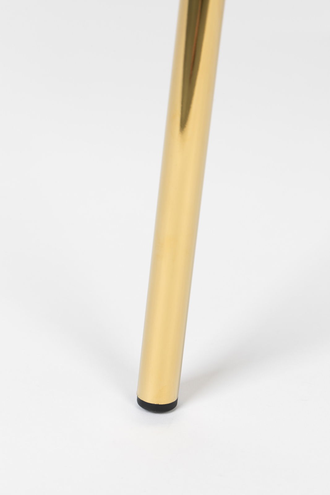 Nahaufnahme eines goldenen Stuhlbeins mit schwarzem Fuß auf weißem Hintergrund.