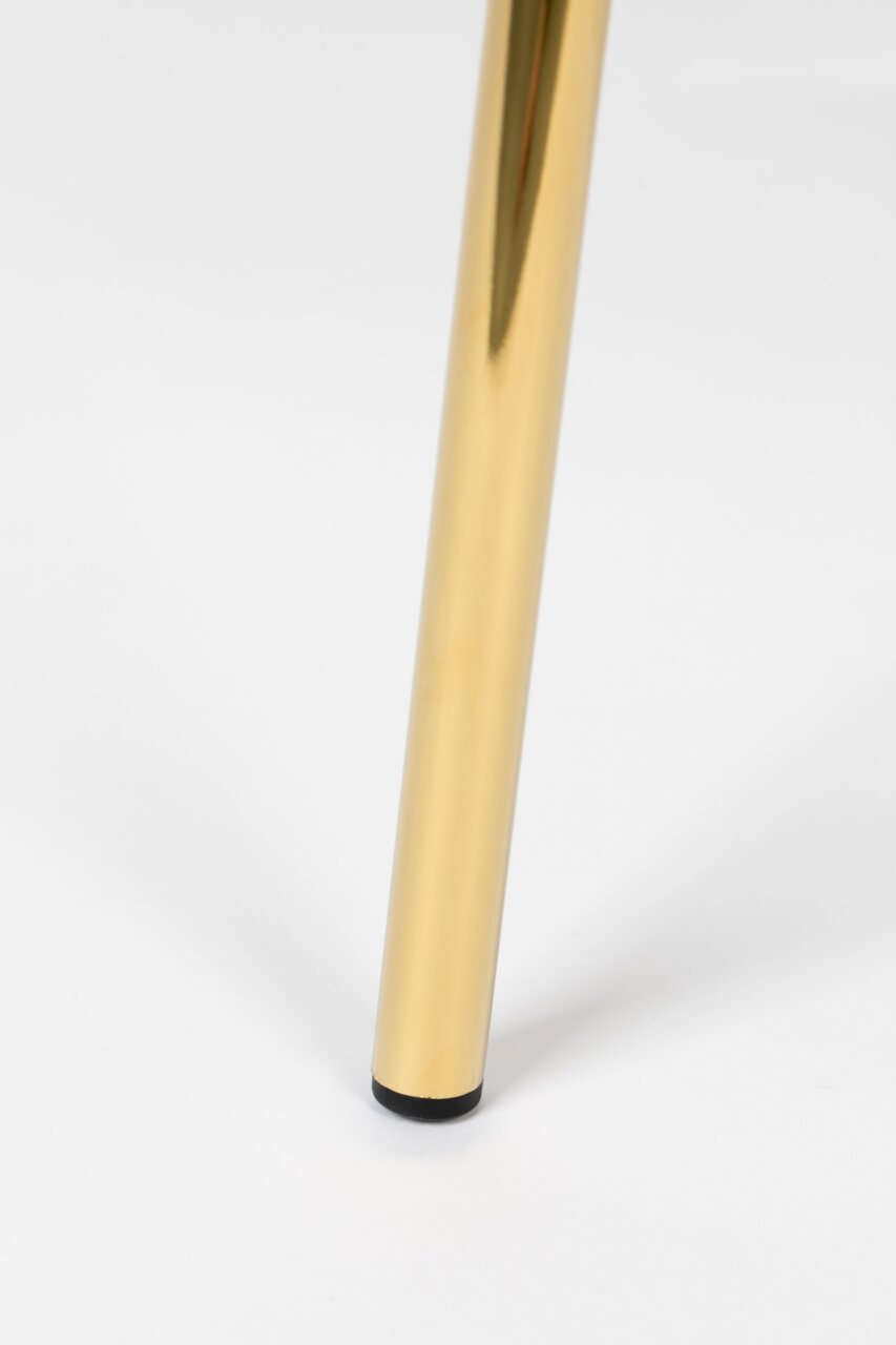 Close-up van een gouden stoelpoot met een zwarte voet op een witte achtergrond.