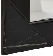 Nahaufnahme eines Spiegels mit schwarzem, geometrischem Rahmen und Marmoroptik, perspektivisch von der Seite aufgenommen.