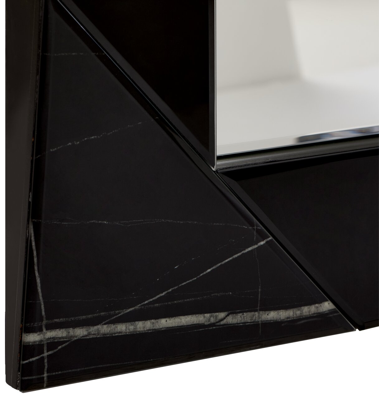 Nahaufnahme eines Spiegels mit schwarzem, geometrischem Rahmen und Marmoroptik, perspektivisch von der Seite aufgenommen.