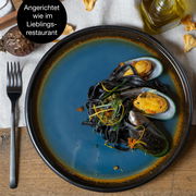 Vogelperspektive auf einen blau-braunen Teller mit Muscheln und schwarzer Pasta, angerichtet wie im Lieblingsrestaurant.