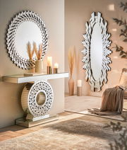 Moderner Konsolentisch mit rundem Spiegel, dekoriert mit Kerzen und Vasen, in einem stilvollen Wohnzimmerambiente, seitliche Perspektive.