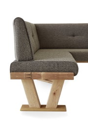 Zijaanzicht van een moderne hoekbank met grijze stoffen bekleding en een houten frame.
