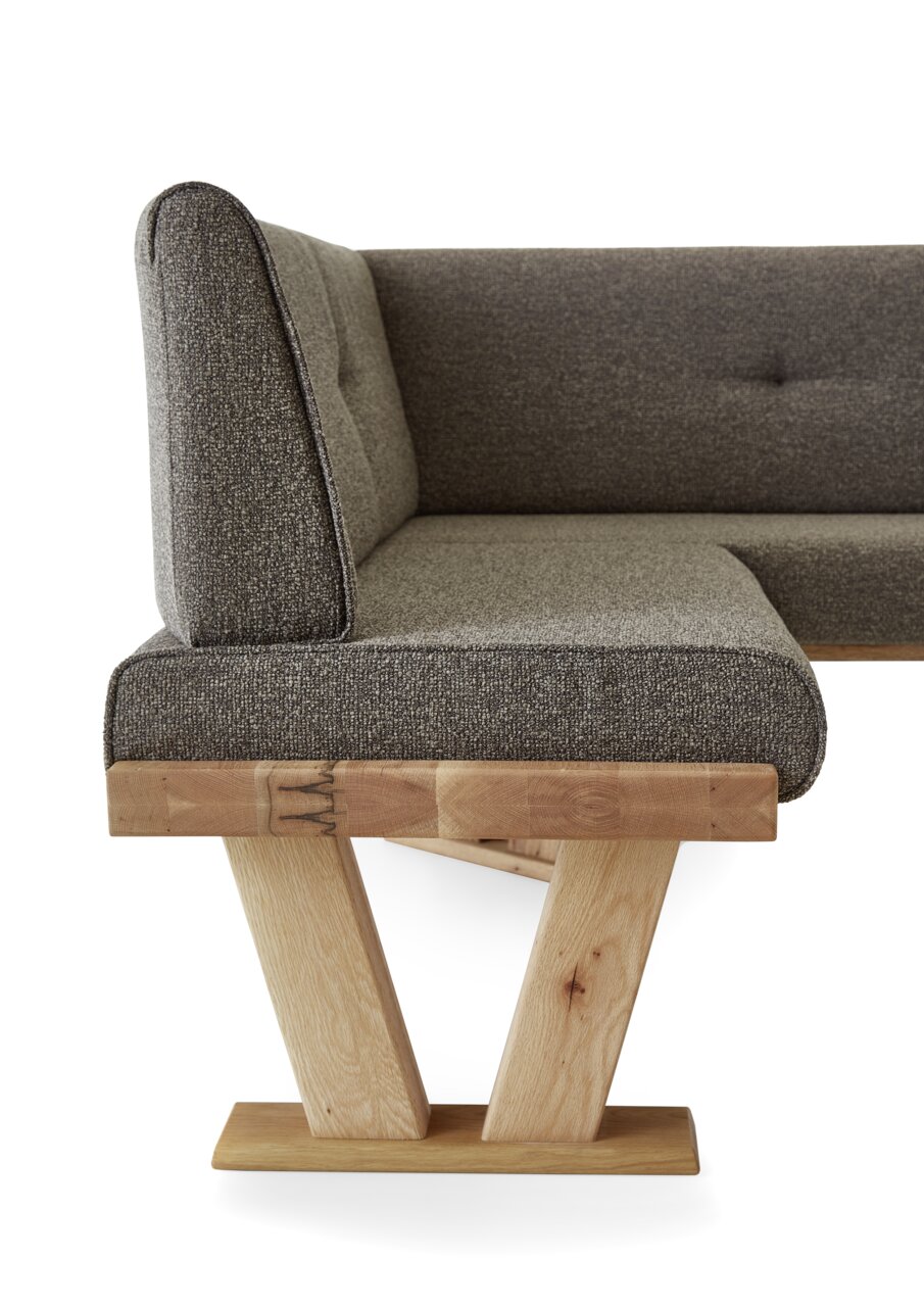 Zijaanzicht van een moderne hoekbank met grijze stoffen bekleding en een houten frame.