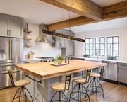 Moderne led-hanglamp boven een houten kookeiland, zijaanzicht.