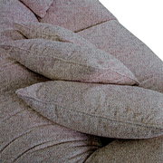 Close-up van kussens op een grote ROMANTICO-bank met een gestructureerde stoflook, gezien van bovenaf.