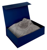 Geschenkset in einer offenen blauen Box mit weicher, grauer Decke, Ansicht von oben.